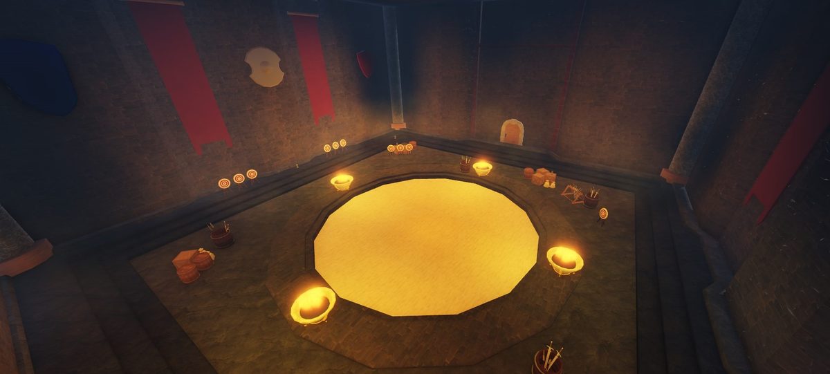 Torchlit training hall with a circular sand pit