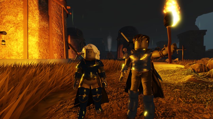 Two armored characters on a torchlit path at night outside a settlement